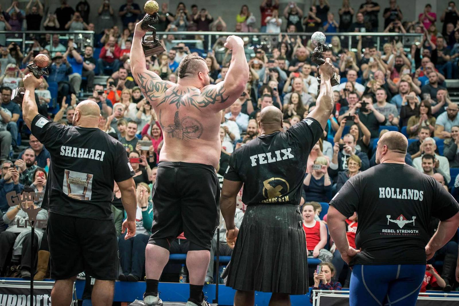 Rebel Strength-sponsored strongman athletes celebrating on the winners' podium